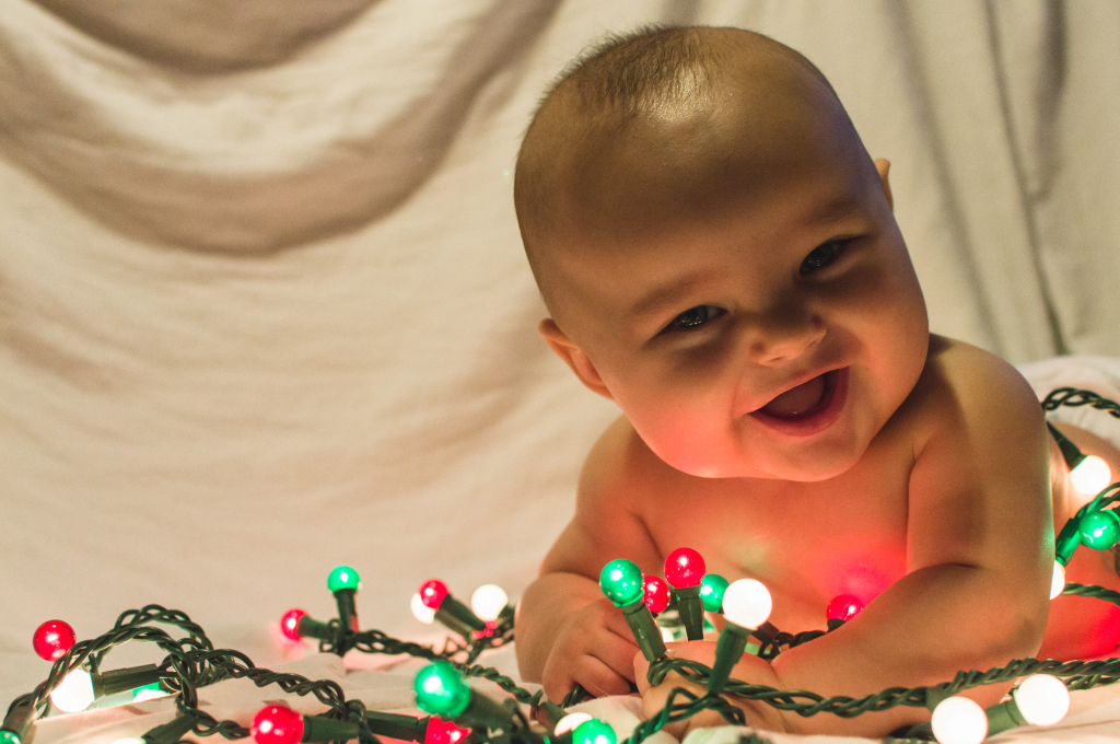 baby playing with christmas lights