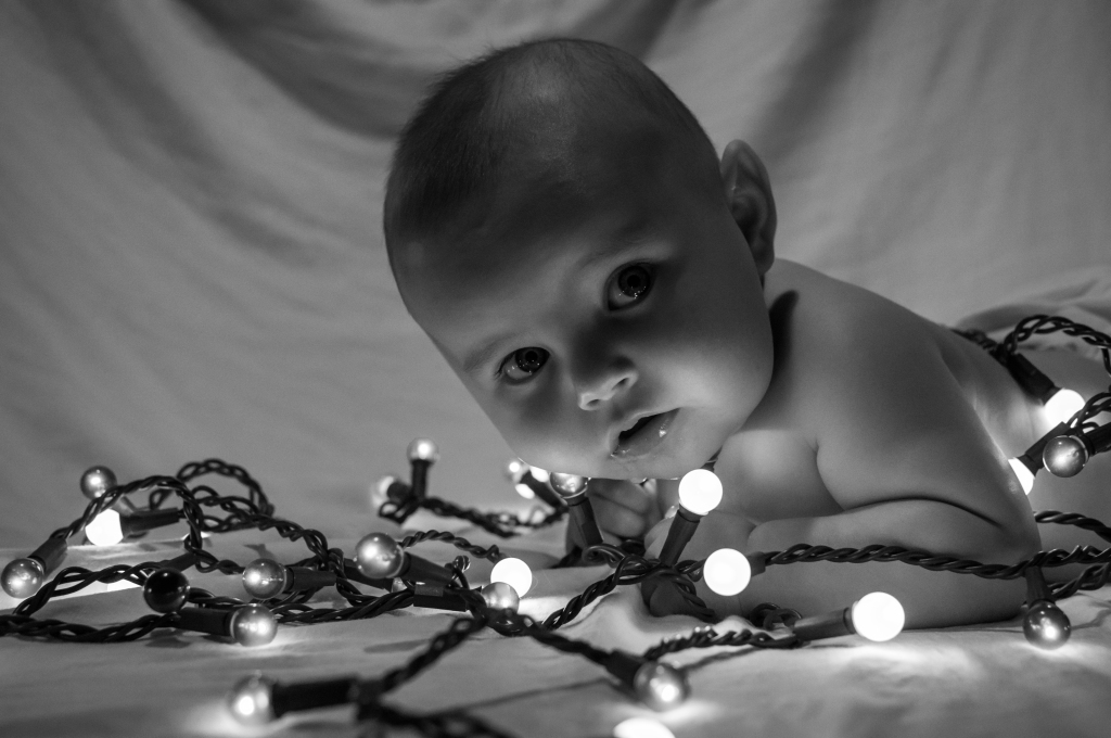 baby playing with christmas lights